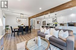 Living room with beamed ceiling, sink, and light wood-type flooring - 