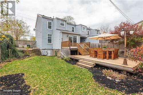 Rear view of house with a lawn and a deck - 19 Strachan Street E, Hamilton, ON 