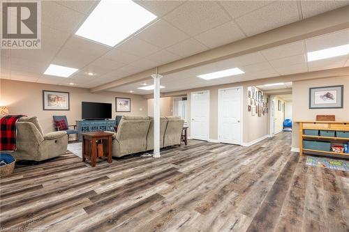 Living room featuring a drop ceiling and wood-type flooring - 5 Twentyplace Boulevard, Mount Hope, ON 