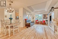 Dining room featuring light hardwood / wood-style floors, a notable chandelier, and a raised ceiling - 