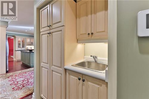 Kitchen featuring ornamental molding, dark wood-type flooring, and sink - 218 Northshore Boulevard W, Burlington, ON 