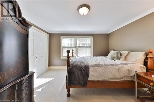 Carpeted bedroom with ornamental molding and a closet - 218 Northshore Boulevard W, Burlington, ON 