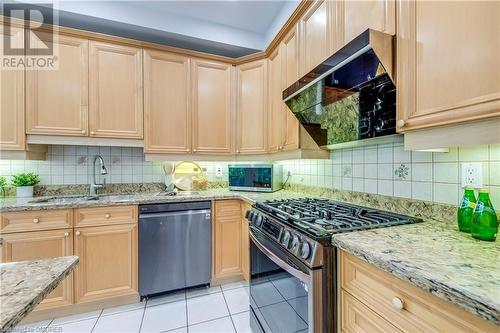 Kitchen with extractor fan, stainless steel appliances, light brown cabinetry, and light tile patterned flooring - 2303 Hill Ridge Court Unit# 10, Oakville, ON 