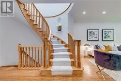 Stairway with hardwood / wood-style floors and ornamental molding - 