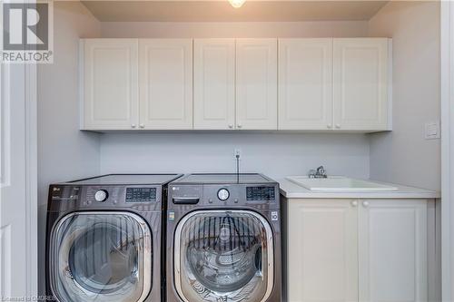 Clothes washing area with cabinets, sink, and washing machine and clothes dryer - 2303 Hill Ridge Court Unit# 10, Oakville, ON 