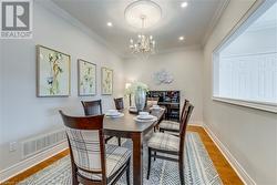 Dining room featuring ornamental molding, hardwood / wood-style flooring, and an inviting chandelier - 