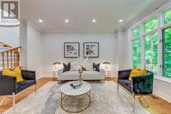 Living room with wood-type flooring and ornamental molding - 