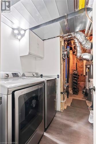 Washroom with cabinets, hardwood / wood-style flooring, washer and dryer, and water heater - 466 Normanton Street, Port Elgin, ON - Indoor Photo Showing Laundry Room