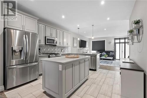 Kitchen with light hardwood / wood-style floors, sink, appliances with stainless steel finishes, a center island, and gray cabinetry - 466 Normanton Street, Port Elgin, ON - Indoor Photo Showing Kitchen With Upgraded Kitchen