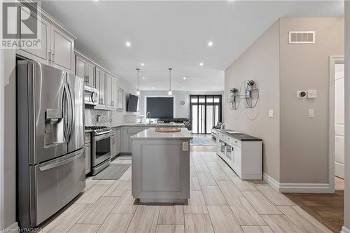 Kitchen featuring a center island, kitchen peninsula, hanging light fixtures, gray cabinetry, and appliances with stainless steel finishes - 466 Normanton Street, Port Elgin, ON - Indoor Photo Showing Kitchen With Upgraded Kitchen