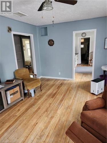 Living room with light wood-type flooring, a textured ceiling, and ceiling fan - 765 7Th Street A E, Owen Sound, ON - Indoor