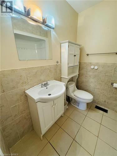 Bathroom with tile walls, tile patterned flooring, vanity, and toilet - 49 Beaver Crescent, North Bay, ON - Indoor Photo Showing Bathroom