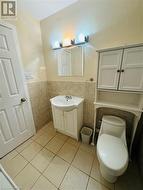 Bathroom with vanity, tile patterned flooring, toilet, and tile walls - 