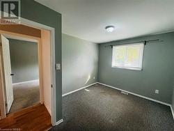 Empty room with dark wood-type flooring - 