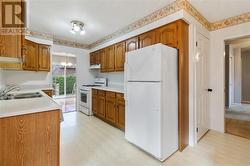 Kitchen with door to right of fridge that leads downstairs - 