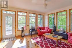 Sunroom / solarium featuring plenty of natural light, ceiling fan, and a baseboard heating unit - 