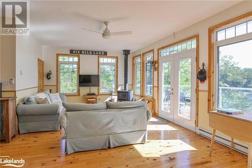 Living room with a wealth of natural light, a wood stove, and light hardwood / wood-style floors - 1320 360 Island, Port Severn, ON - Indoor Photo Showing Living Room