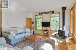 Living room with a wood stove, light hardwood / wood-style flooring, and baseboard heating - 