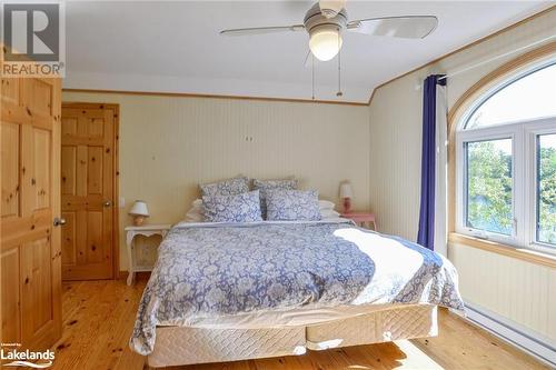 Bedroom featuring ceiling fan, a baseboard radiator, and light wood-type flooring - 1320 360 Island, Port Severn, ON - Indoor Photo Showing Bedroom