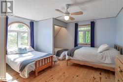 Bedroom featuring ceiling fan and light wood-type flooring - 