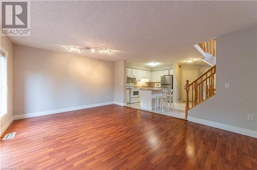 Unfurnished living room featuring a textured ceiling and hardwood / wood-style flooring - 421 Beaver Creek Road, Waterloo, ON - Indoor Photo Showing Other Room