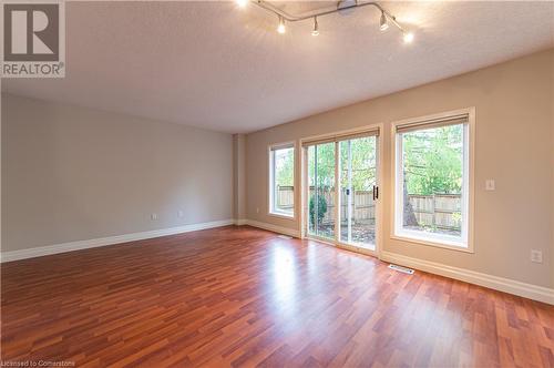 Unfurnished room featuring wood-type flooring, track lighting, and a textured ceiling - 421 Beaver Creek Road, Waterloo, ON - Indoor Photo Showing Other Room