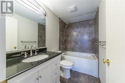 Full bathroom with vanity, toilet, and tiled shower / bath combo - 