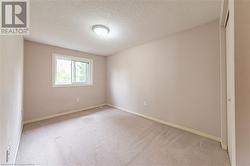 Unfurnished room with a textured ceiling and light colored carpet - 