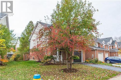 View of property hidden behind natural elements with a garage, a front yard, and covered porch - 421 Beaver Creek Road, Waterloo, ON - Outdoor