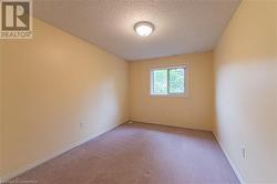 Unfurnished room with light colored carpet and a textured ceiling - 