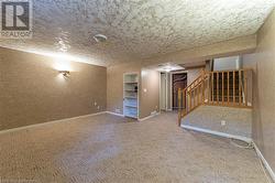 Basement featuring a textured ceiling and carpet - 