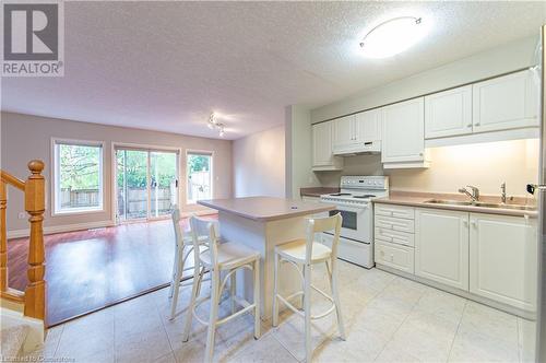 Kitchen featuring light hardwood / wood-style floors, white cabinetry, sink, and electric stove - 421 Beaver Creek Road, Waterloo, ON - Indoor Photo Showing Kitchen With Double Sink