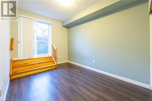 Spare room featuring dark hardwood / wood-style flooring and a textured ceiling - 62 Balsam Street Unit# T113, Waterloo, ON - Indoor Photo Showing Other Room