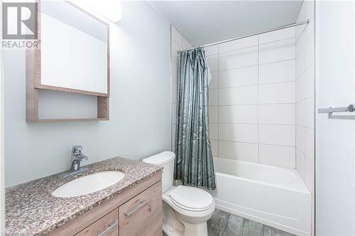 Full bathroom featuring hardwood / wood-style flooring, vanity, toilet, and shower / bath combo with shower curtain - 62 Balsam Street Unit# T113, Waterloo, ON - Indoor Photo Showing Bathroom