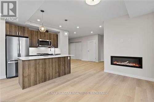 605 - 118 West Street, Port Colborne (878 - Sugarloaf), ON - Indoor Photo Showing Other Room With Fireplace