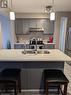 Kitchen featuring sink, light stone counters, appliances with stainless steel finishes, hanging light fixtures, and gray cabinets - 642 Inglis Falls Place, Waterloo, ON  - Indoor Photo Showing Kitchen With Double Sink With Upgraded Kitchen 