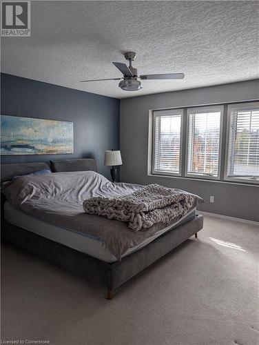 Carpeted bedroom featuring a textured ceiling and ceiling fan - 642 Inglis Falls Place, Waterloo, ON - Indoor Photo Showing Bedroom