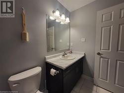 Bathroom with toilet, vanity, and tile patterned flooring - 