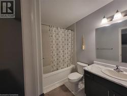 Full bathroom with vanity, shower / tub combo with curtain, tile patterned flooring, and toilet - 