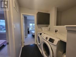 Washroom featuring separate washer and dryer and cabinets - 