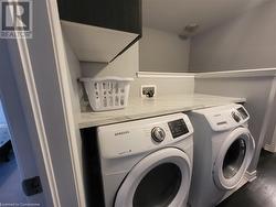 Laundry area featuring dark hardwood / wood-style floors and independent washer and dryer - 