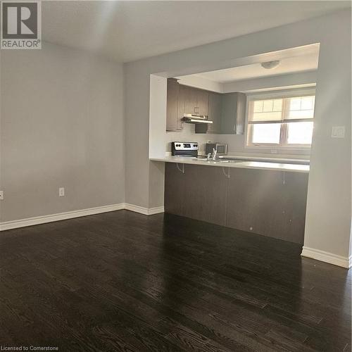 Kitchen with stove, dark wood-type flooring, ventilation hood, kitchen peninsula, and a breakfast bar area - 39 Appleby Street, Kitchener, ON - Indoor Photo Showing Kitchen