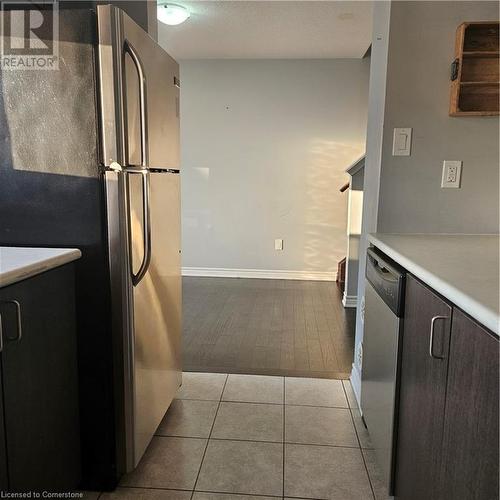 Kitchen with dishwashing machine, refrigerator, dark brown cabinets, and light hardwood / wood-style floors - 39 Appleby Street, Kitchener, ON - Indoor Photo Showing Kitchen