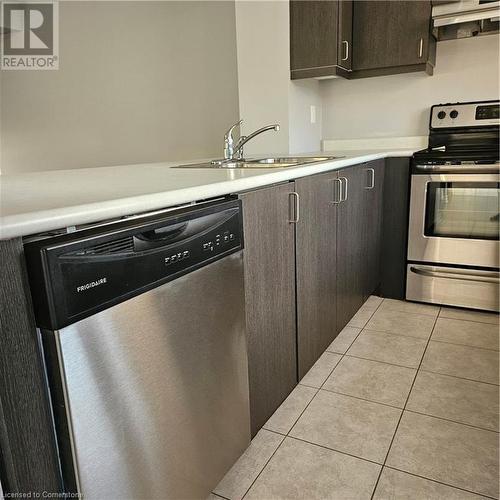 Kitchen featuring stove, dark brown cabinets, extractor fan, sink, and dishwasher - 39 Appleby Street, Kitchener, ON - Indoor Photo Showing Kitchen With Stainless Steel Kitchen With Double Sink