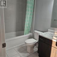 Full bathroom with tile patterned flooring, vanity, toilet, and shower / tub combo - 