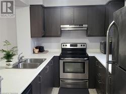 Kitchen featuring stainless steel appliances, sink, and light tile patterned floors - 