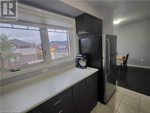 Kitchen featuring light tile patterned flooring and stainless steel fridge - 39 Appleby Street, Kitchener, ON - Indoor