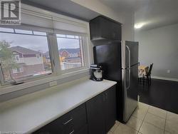 Kitchen featuring light tile patterned flooring and stainless steel fridge - 