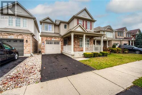 View of property with a garage, a front lawn, and a porch - 66 Abbott Crescent, Cambridge, ON - Outdoor With Deck Patio Veranda With Facade