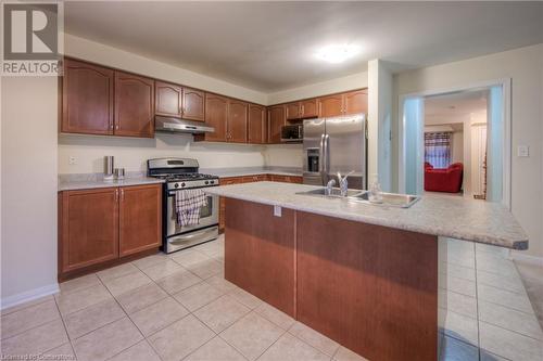 Kitchen with stainless steel appliances, light tile patterned flooring, sink, and a kitchen island with sink - 66 Abbott Crescent, Cambridge, ON - Indoor Photo Showing Kitchen With Double Sink